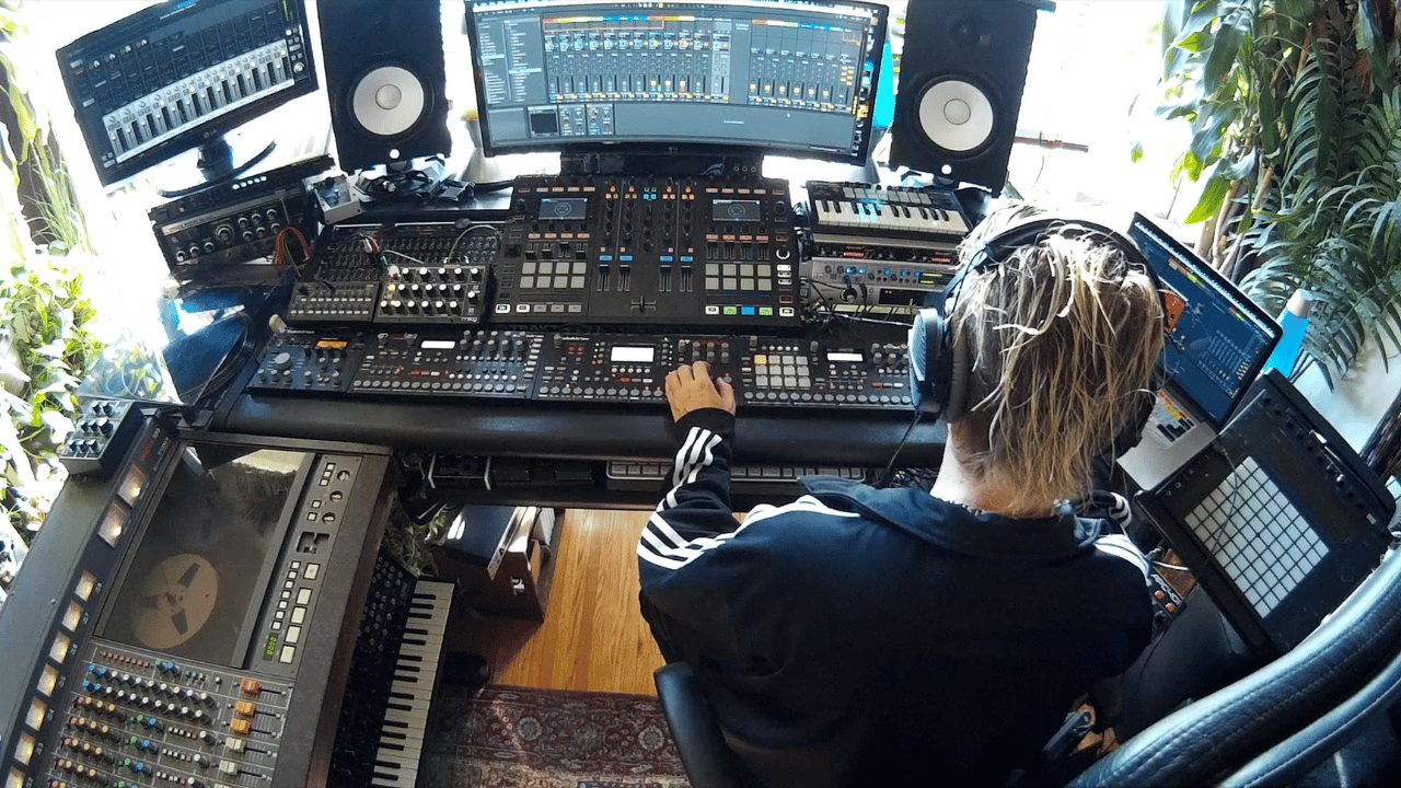 Music producer wearing headphones working at a home studio desk